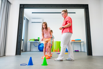 Kids group physio therapy. Children and physical therapist exercising during session. Bilateral...