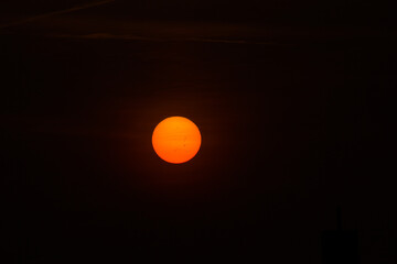 Close up on the Sun during sunset, solar spots are visible.