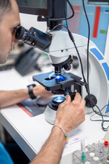 Close-up of a veterinarian working with a microscope
