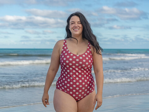 Curvy woman in swimsuit radiating body positivity at beach