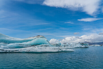 Joekulsarlon Glacier Lagoon Landscape with blue ice at south Iceland, background a mountain range with snow