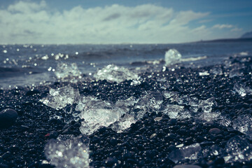 Chunks of ice and broken icebergs on a volcanic black sand beach at Diamond Beach in Iceland