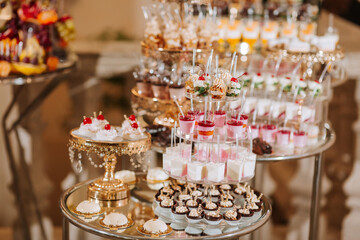 A table full of desserts and drinks with a fancy gold plated stand