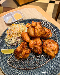 Tori no Karage is a Japanese-style fried chicken coated in flour, served with salad, mayonnaise, and lemon slices.