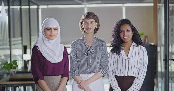 Indian Asian happy young adult gen z proud women friends lady wear hijab scarf look cam indoor work place teen mix girls curly hair expert female staff group agent team do pose job office day time - Powered by Adobe