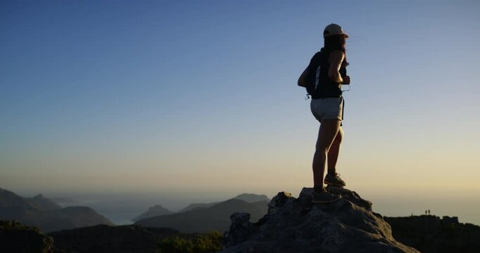 Woman, hiking and standing for adventure, mountain top and peak, outdoor and backpack. Hiker, fitness and climber for training, workout and nature to explore, hobby and summit kilimanjaro for freedom