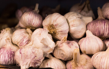 Heads of fragrant garlic in baskets on market counter