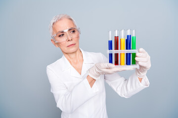 Photo of old woman serious scientist look analyze test tube flask isolated grey color background