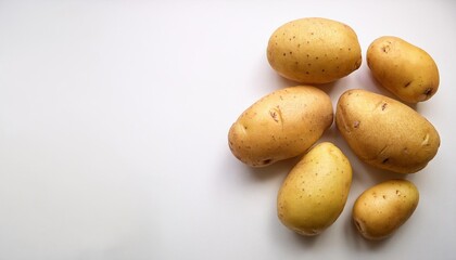 Obraz premium Fresh potatoes displayed on a plain surface, suitable for culinary themes or agricultural promotions.