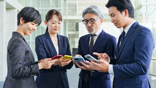 スマホを使うビジネスパーソンのグループ