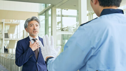 警備員に止められるミドル男性