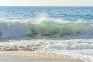 Huge wave breaking on a beach on sunny autumn day