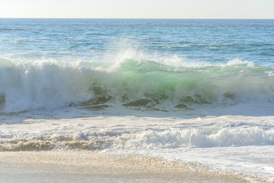 Huge wave breaking on a beach on sunny autumn day