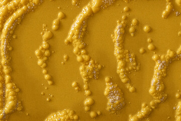 Abstract yellow substance with air bubbles or organic surface texture,  smooth wet and slimy, convex and protruding. Food or organic background, wallpaper, material or banner. 