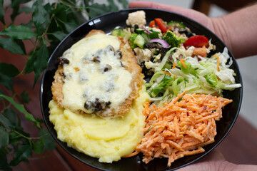 Home made meat dish with salads, in hands dinner time cutlet