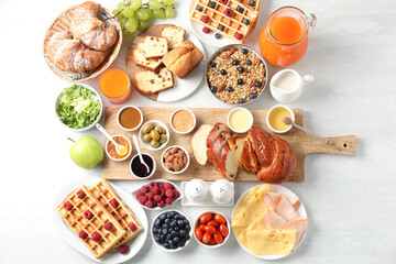 Different meals served for breakfast on white table, flat lay