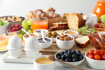 Different meals served for breakfast on white table
