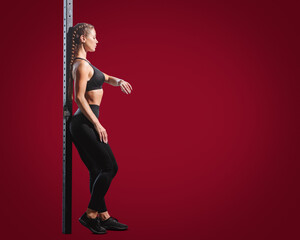 Attractive sporty woman with perfect fit body posing on red background, Girl doing fitness exercises, highlighting workout and health themes
