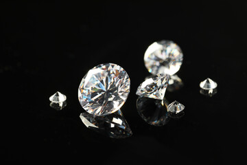 Many beautiful shiny diamonds on black mirror surface, closeup