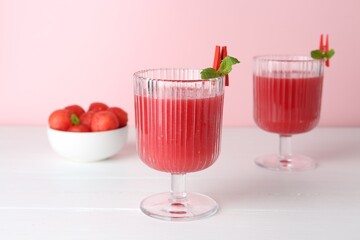 Tasty watermelon drink in glasses and fresh fruit on white wooden table