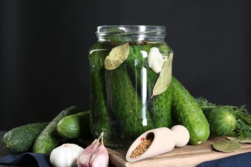 Making pickles. Fresh cucumbers and spices in jar on table, closeup