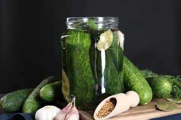Making pickles. Fresh cucumbers and spices in jar on table, closeup