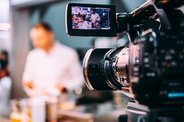 Filming creative video footage with professional video camera during the presentation or workshop.