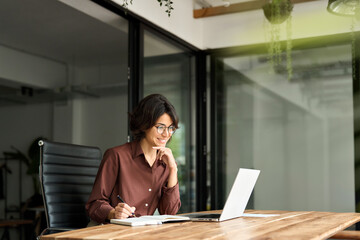 Smiling busy young professional businesswoman hr manager executive looking at laptop computer in...