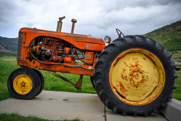 Antique tractor displayed on the agricultural field at the historic farmhouse in Park City, Utah,...