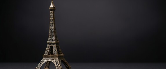 A detailed miniature of the Eiffel Tower against a dark backdrop, representing Parisian elegance and a symbol of romance and travel.