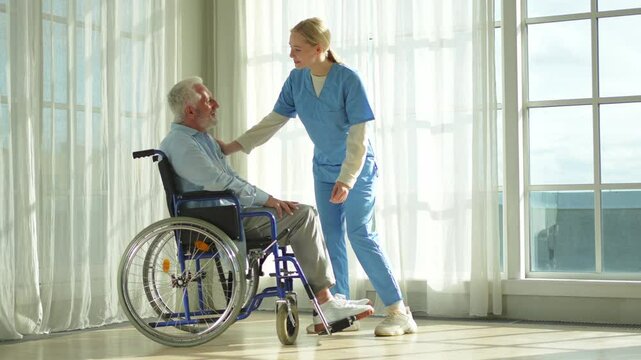 Help support retirement healthcare. Nurse helping old man in wheelchair. Patient and woman in nursing home for medical caregiver. Nurse taking care of paralyzed man in chair for people with disability