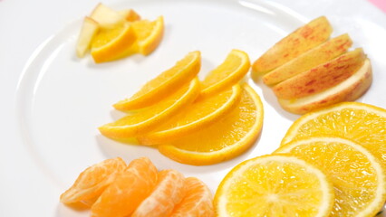 organic fresh orange, apple, malta decorated on white ceramic plate with close shot 