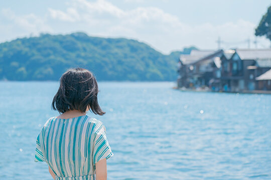 日本の美しい伊根湾と舟屋の景色を眺める女性