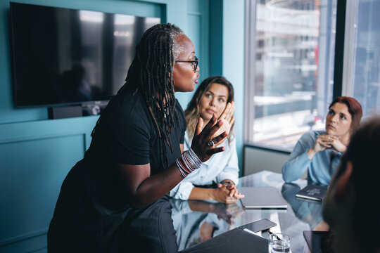 Mature black business woman discussing her strategy with her team in a boardroom