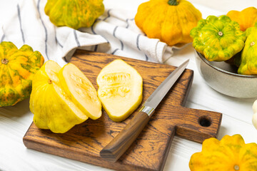 Pattypan zucchini on a textured kitchen table. squash. Fresh organic pattypan squashes on...