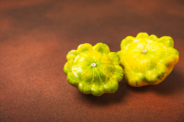 Pattypan zucchini on a textured kitchen table. squash. Fresh organic pattypan squashes on...