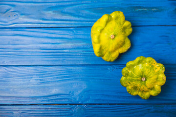 Pattypan zucchini on a textured kitchen table. squash. Fresh organic pattypan squashes on...