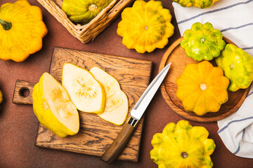 Pattypan zucchini on a textured kitchen table. squash. Fresh organic pattypan squashes on...