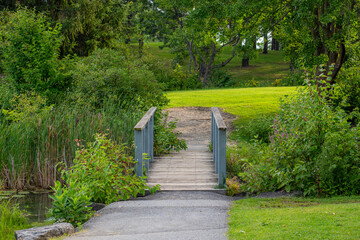 A centred wooden walkway passes through a river in the park