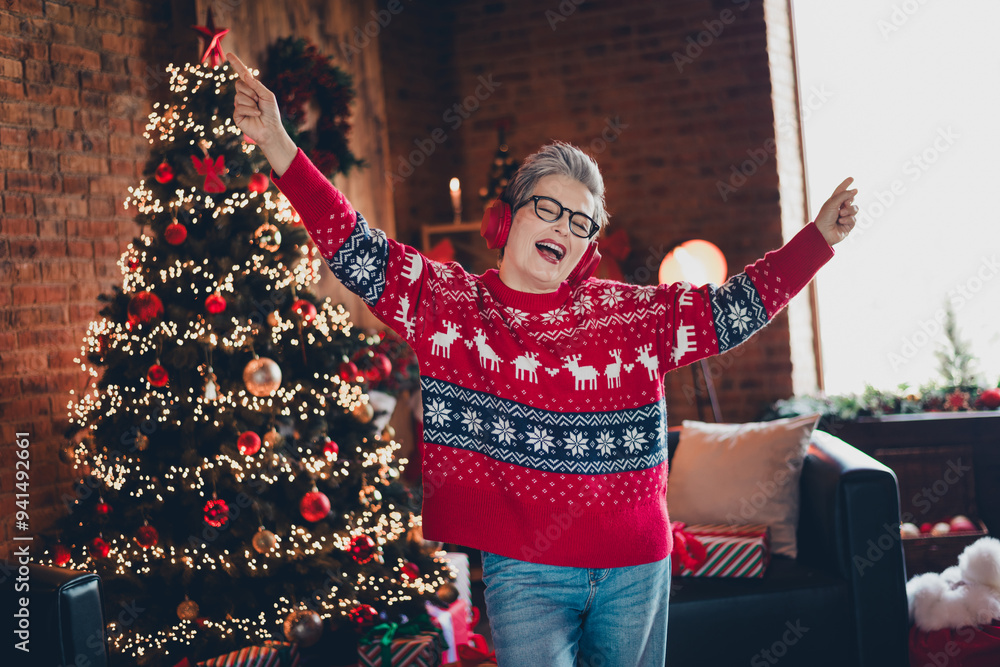 Wall mural Portrait of positive nice person have fun dancing point fingers listen christmas songs headphones decorated house indoors