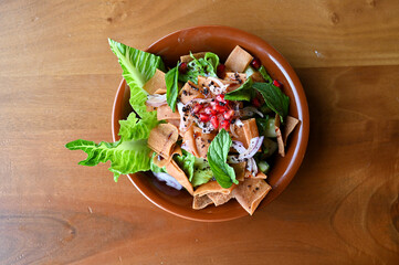 A vibrant bowl of Lebanese Fattoush salad made with fresh vegetables, mixed greens, and crispy pita...