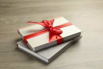 Books with ribbon as gift on wooden table