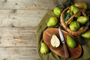 Fresh green pears, knife and napkin on wooden table, flat lay. Space for text