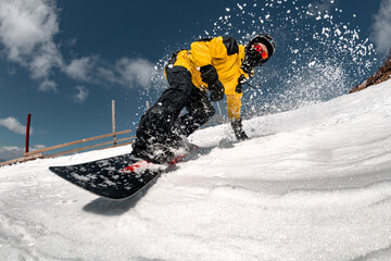 Extreme close up photo of snowboarder is riding at ski slope against blue sky and powder snow. Ski resort concept