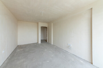 New empty room under construction. Plaster walls. New home. Concrete walls. Interior renovation.