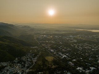 Obraz premium Aerial view taken from Margalla Hills of a the sun rising over Rawal Dam and the outskirts of Islamabad, Islamabad Capital Territory, Pakistan
