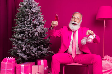 Photo of elderly mature grandfather santa claus sit chair hold christmas tree toys raise champagne...