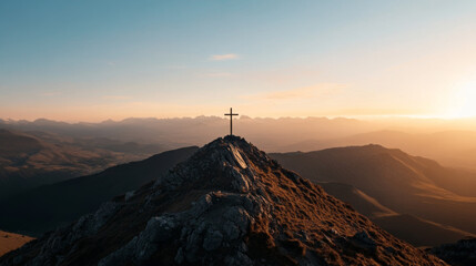A cross is on top of a mountain, with a beautiful sunset in the background