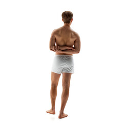 Fototapeta premium Rear view photo of young man in white underwear posing holding hands behind back against white studio background. Posture. Concept of male health, natural beauty people, fashion, self care.