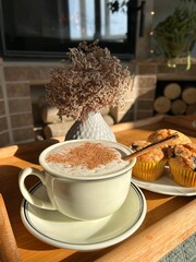 Cozy breakfast on the bamboo tray with cappuccino and blueberry muffins. Romantic breakfast near the fireplace.	
